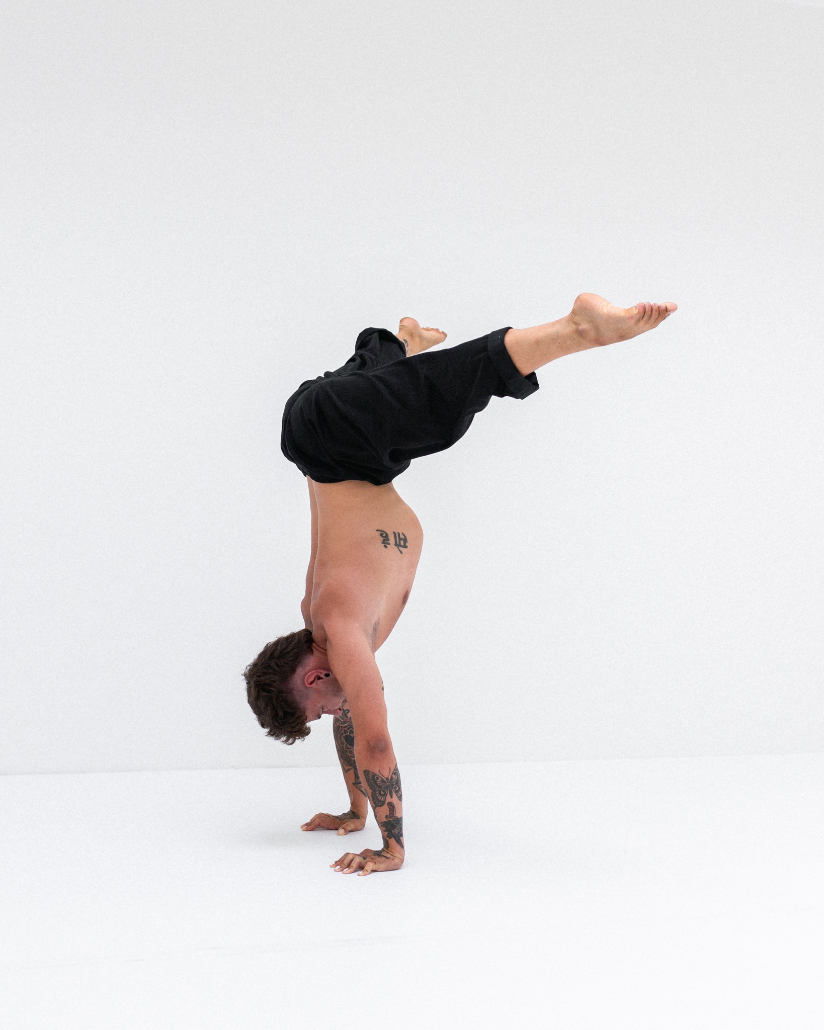 Robin demonstriert einen Straddle Handstand in einem Bewegungsraum in Luzern für den Handstand Online Workshop